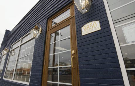 Contemporary building with navy blue brick facade and large windows.