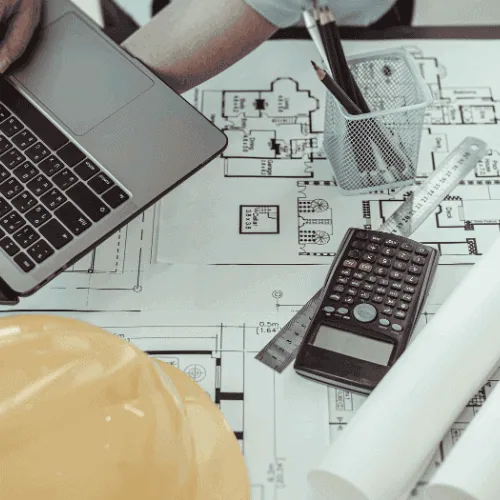 design-budgeting A contractor using a blueprint and calculator for renovation project design and budgeting
