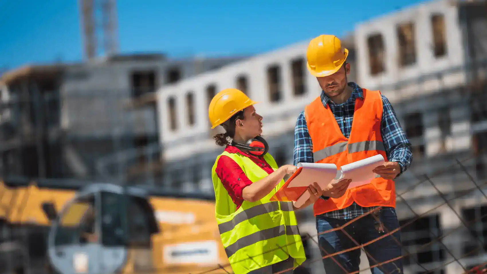 Construction workers discussing plans at a building site.