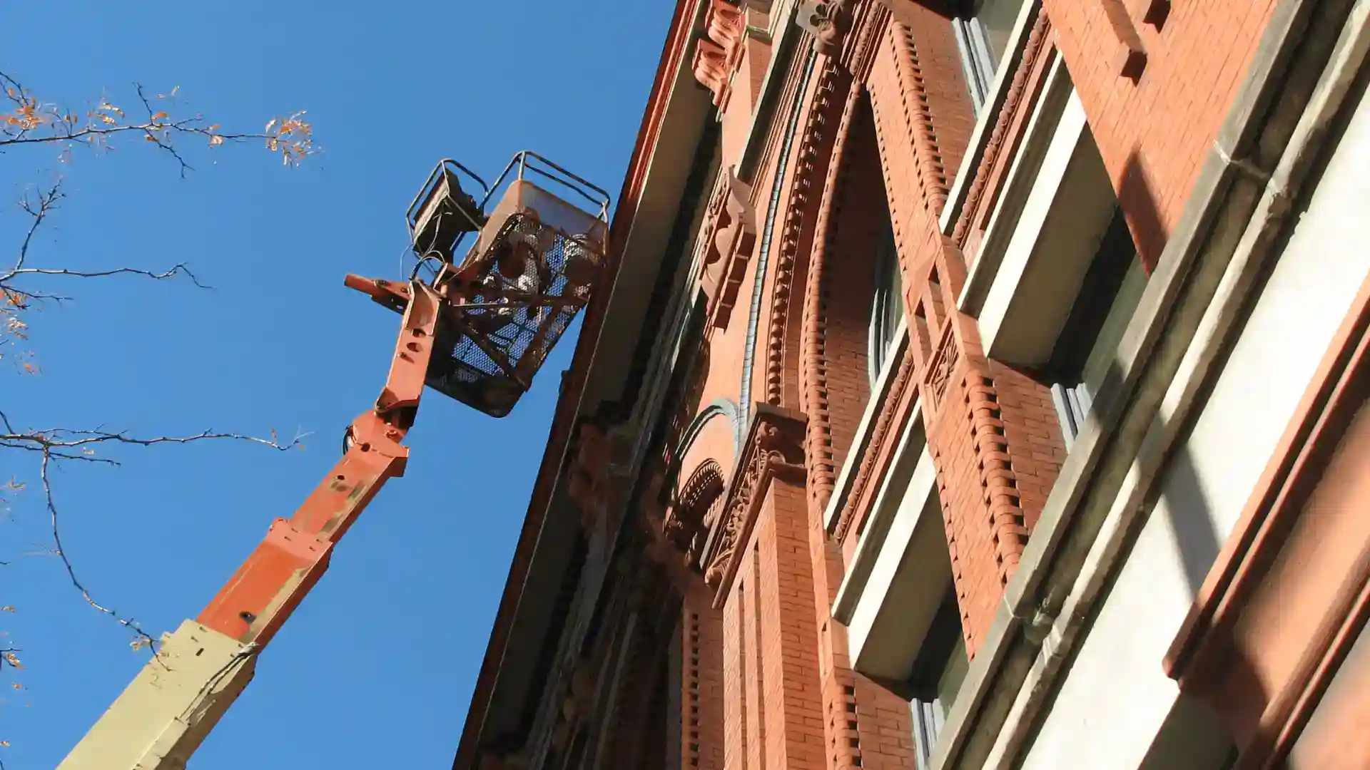 Historic building renovation with crane and clear blue sky.