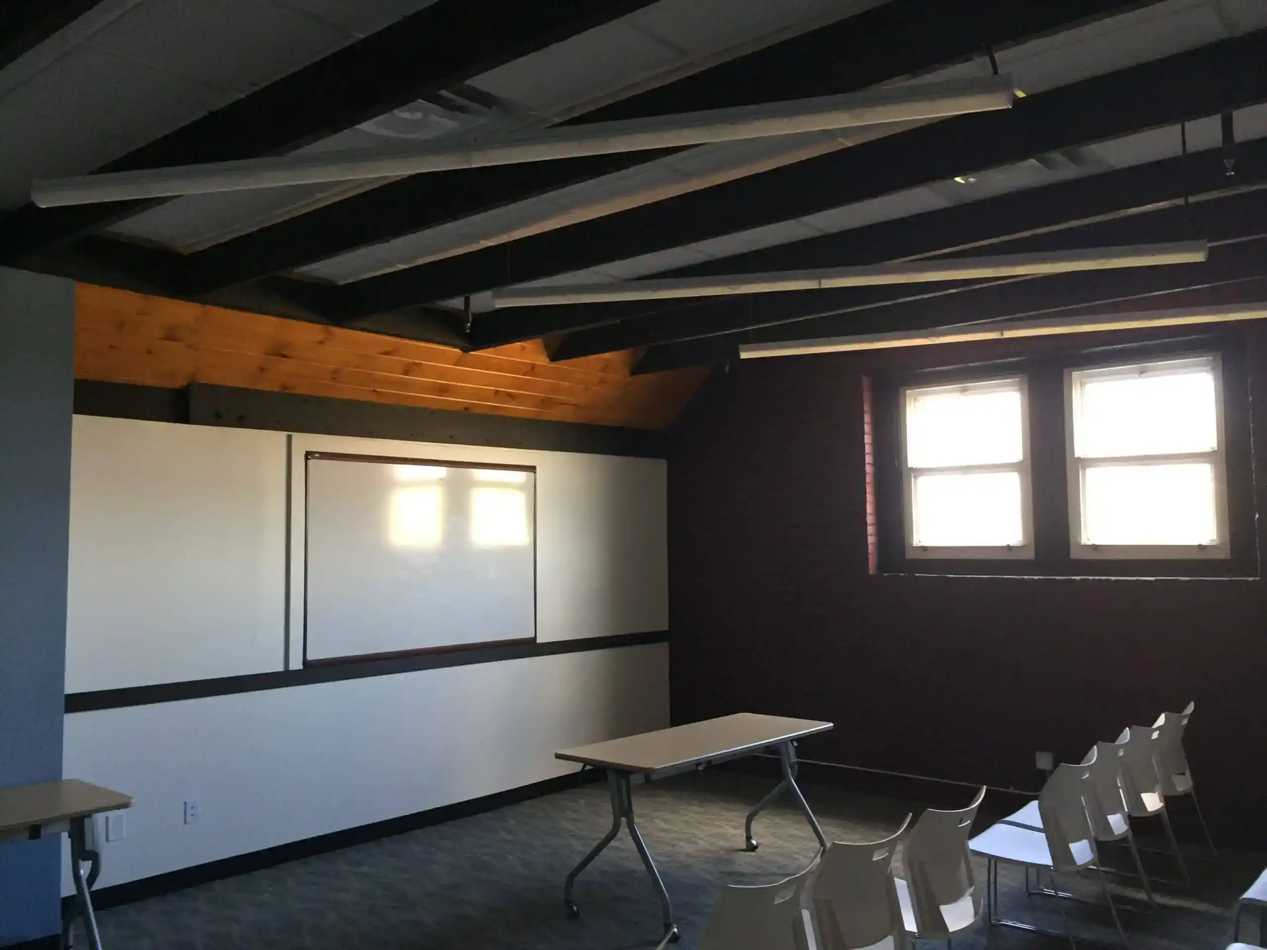 School interior classroom renovation with large windows, whiteboard, and chairs for students.